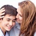 mother smiling and hugging her son
