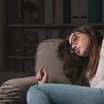 depressed girl laying on couch